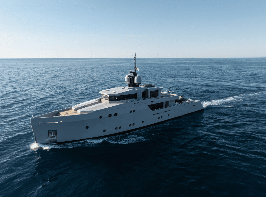 A sleek, modern yacht cruising on the open sea under a clear sky, showcasing its streamlined design and luxury amenities.